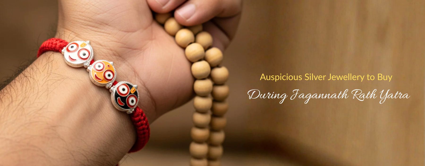 Hand wearing Jagannath silver bracelet beside wooden prayer beads closely.